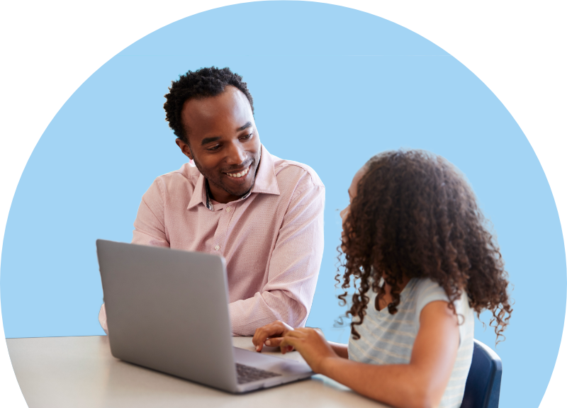 Teacher helping student at laptop